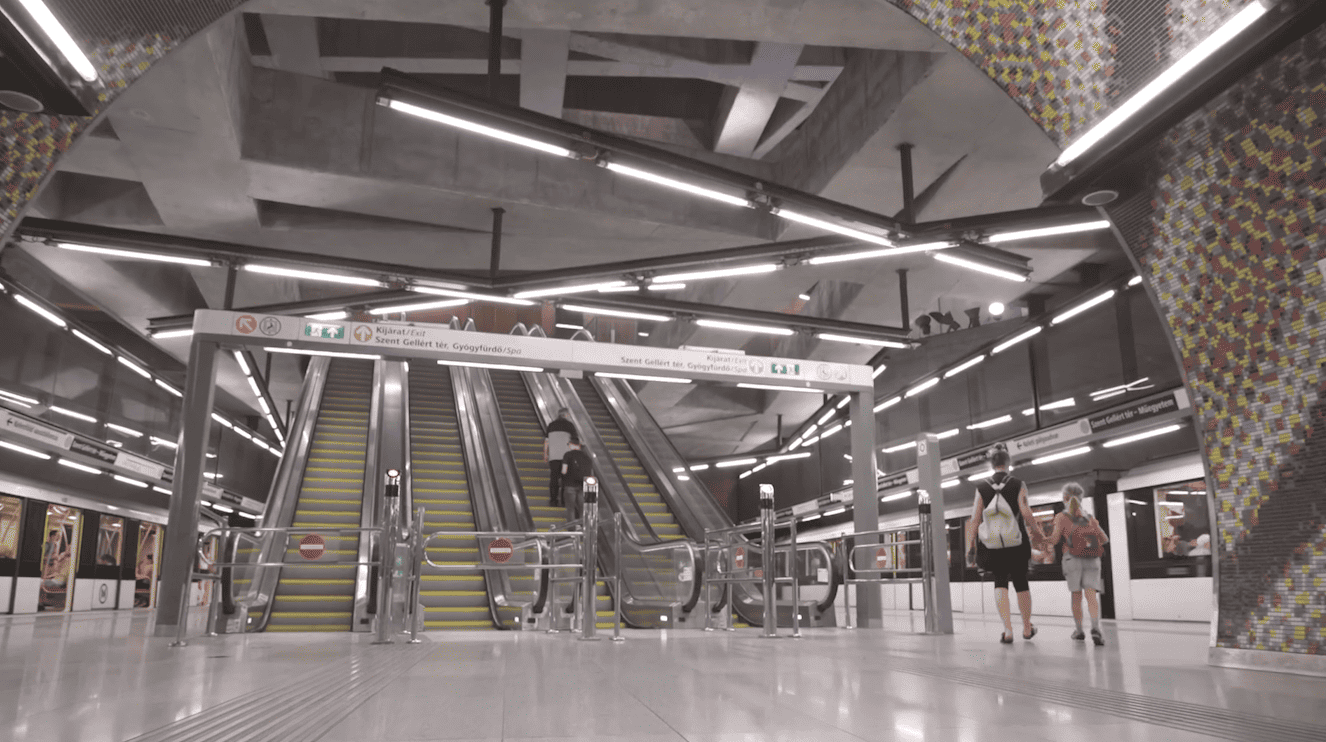 Fömterv: Bridging Traditions presents an artist's rendering of a futuristic subway station featuring sleek escalators that epitomize the philosophy of Designing Tomorrow.